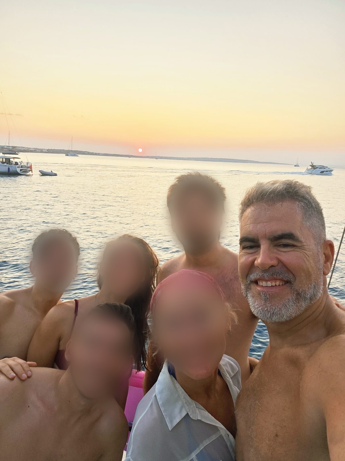 La tripulación en la popa del Truhán viendo el atardecer en Formentera